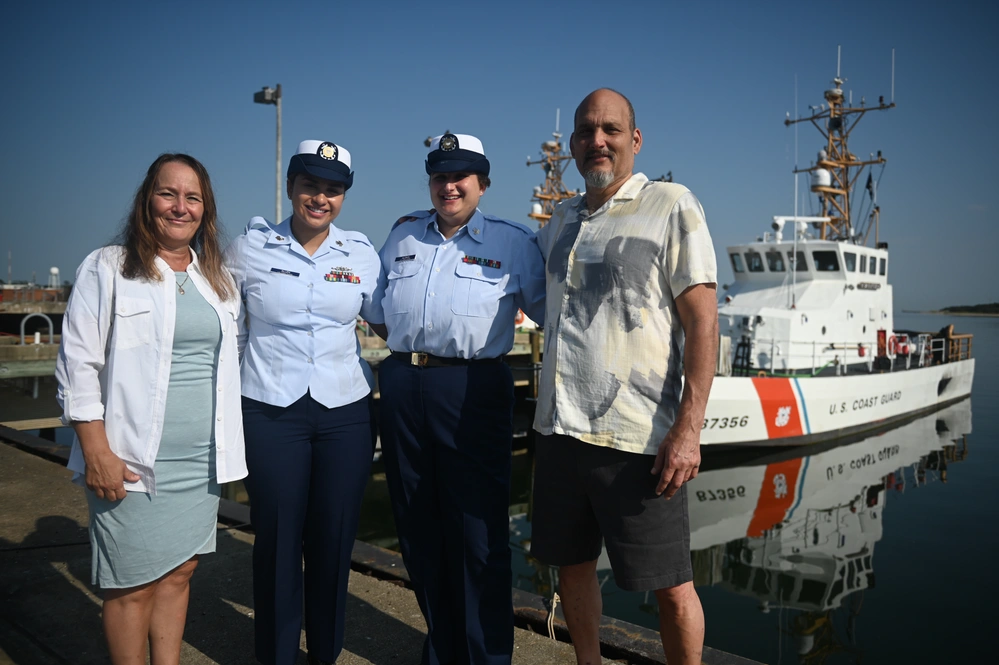 Petty Officer 2nd Class Gabriella Alongi and Petty Officer 1st Class Jennaya Allen pose for a photo with their parents in front of the USCGC Sailfish (WPB-87356) following Allen's advancement ceremony at Coast Guard Station Little Creek in Virginia Beach, Virginia, Aug. 26, 2024. Allen was relieved as the primary culinary specialist aboard the USCGC Sailfish (WPB-87356) by her own sister, CS2 Alongi, as CS1 Allen makes her way to the USCGC Frederick Hatch (WPC 1143) in Guam. (U.S. Coast Guard Photo by Petty Officer 2nd Class Ryan L. Noel)