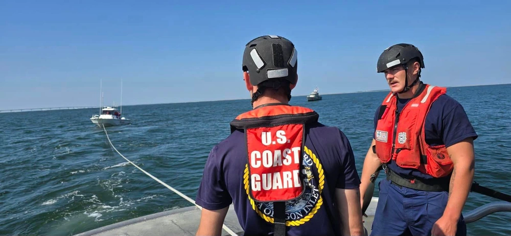 Two crewmembers with a Coast Guard Station Oregon Inlet 47-foot Motor Life Boat crew monitors the tow of a disabled 27-foot vessel over the bar, Oct. 7, 2024, near Oregon Inlet, North Carolina.