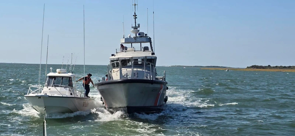 A crewmember with a Coast Guard Station Oregon Inlet 47-foot Motor Life Boat crew departs a disabled 27-foot vessel after trasnferring four passengers to the MLB, Oct. 7, 2024, near Oregon Inlet, North Carolina.