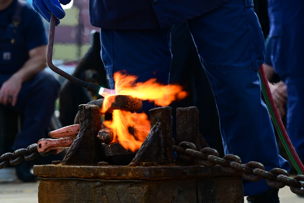 A pin is heated up prior to a heat and beat event Oct. 23, 2024 during the annual Buoy Tender Round-up held in Portsmouth, Virginia.