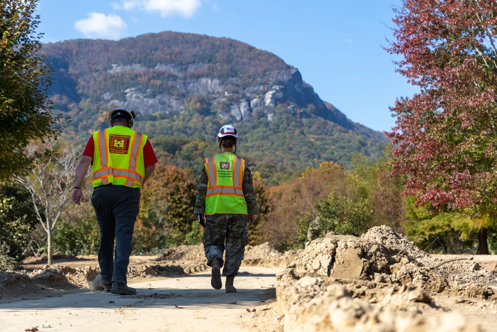 Maj. Brittany Hine, U.S. Army Corps of Engineers battle captain with Task Force Debris, walk along a debris-strewn path during a site assessment at Lake Lure, North Carolina, Oct. 26, 2024.