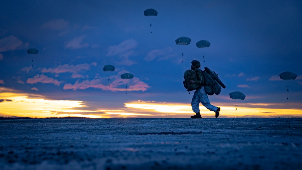 U.S. Army Spc. Logan Calhoun runs toward a designated point after being airdropped from a U.S. Marine Corps KC-130J during a deployment for training (DFT) at Joint Base Elmendorf-Richardson, Alaska, Dec. 10, 2024.