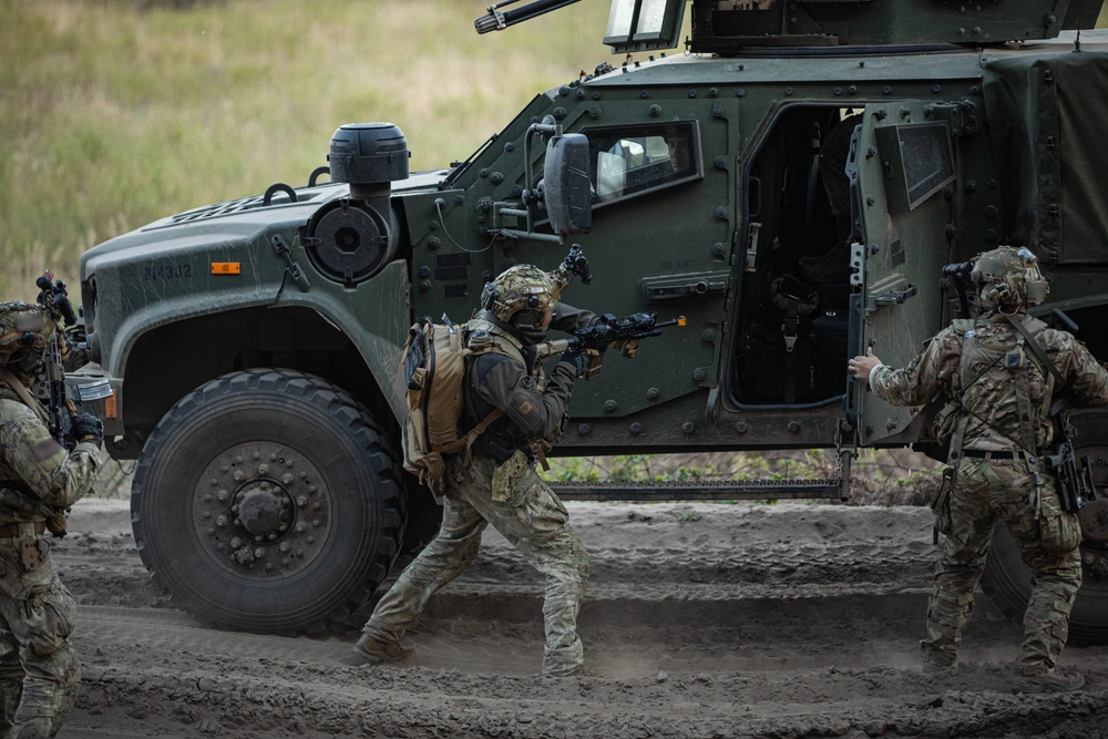 A Green Beret with the U.S. Army 20th Special Forces Group (Airborne) and two Italian special operations forces soldiers secure a vehicle while conducting a simulated ambush during Swift Response 25 in Pabrade, Lithuania, May 12, 2025. Credit: U.S. Army photo by Sgt. Anthony Ackah-Mensah