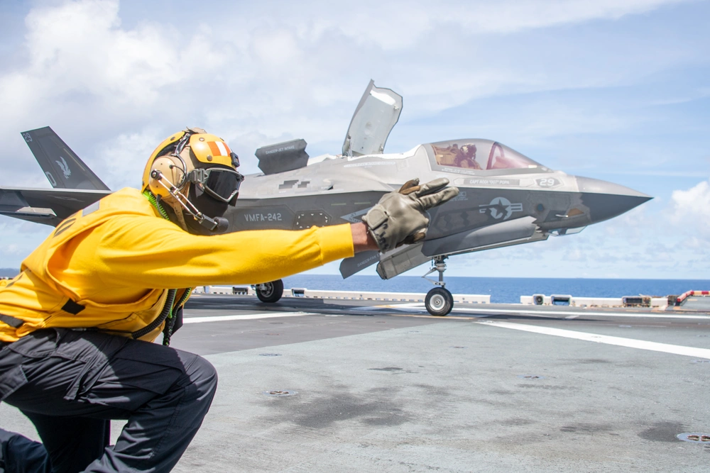Aviation Boatswain’s Mate (Handling) 1st Class Clarence Guidry signals a U.S. Marine Corps F-35B Lightning II aircraft for takeoff during flight operations in the Philippine Sea, Aug. 10, 2025. Credit: Mass Communication Specialist 2nd Class Cole Pursley
