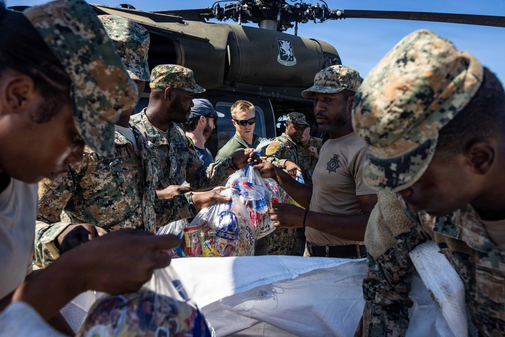 Soldiers unload aid from a military helicopter.