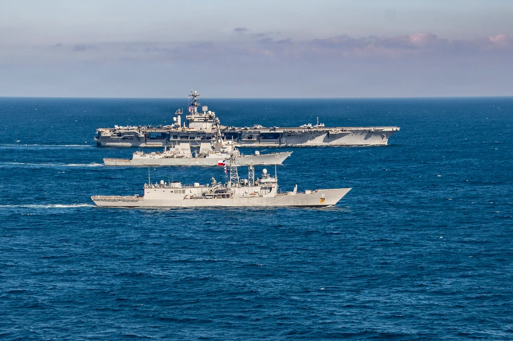 Three naval warships sail in formation.